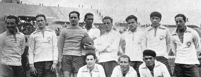 1930 e 1934: Nas primeiras Copas do Mundo, a Seleção vestiu branco, com gola polo em azul amarrada por cordinhas, mangas longas e punhos azuis — Foto: Divulgação CBF