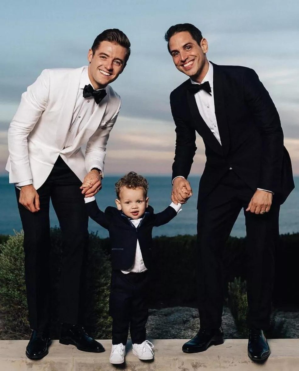 Robbie Rogers ao lado do marido, o produtor Greg Berlanti, e o filho Caleb (Foto: Reprodução / Instagram) — Foto: GQ