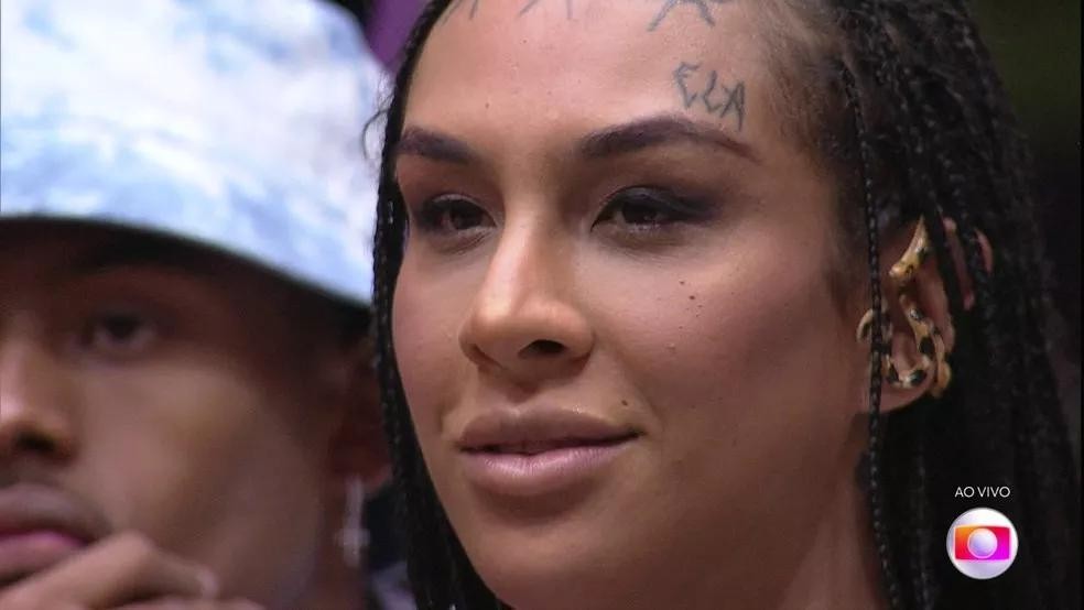 Linn da Quebrada no BBB22. Cantora tem o pronome feminino "ela" tatuado no rosto (Foto: Reprodução/Globo) — Foto: GQ