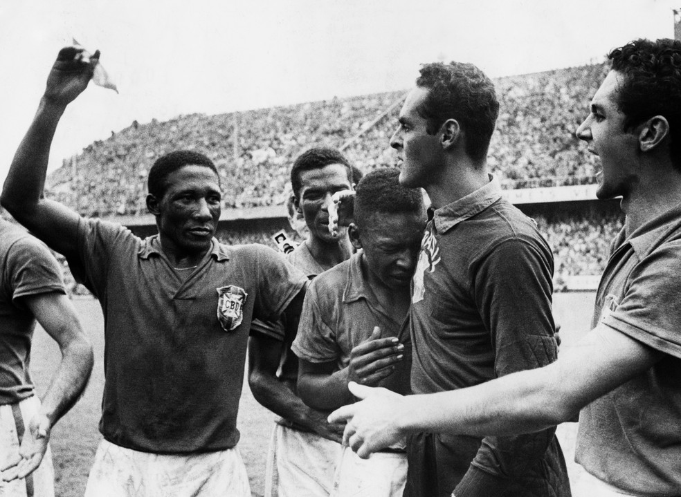 Pelé chora abraçado ao goleiro Gilmar. Ao lado do Rei, o lateral Djalma Santos. Todos comemoram o título de 1958 — Foto: Getty Images