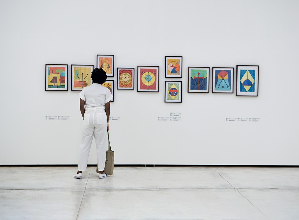 Visitante observa quadros da exposição "3º Ato - Sortilégio", em Inhotim — Foto: Tiago Nunes/Divulgação