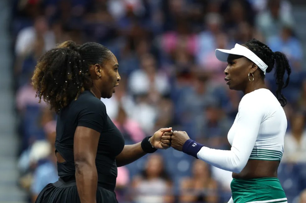 As irmãs veganas Serena e Venus Williams, dos EUA, se cumprimentam no US Open 2022  — Foto: Elsa/Getty Images