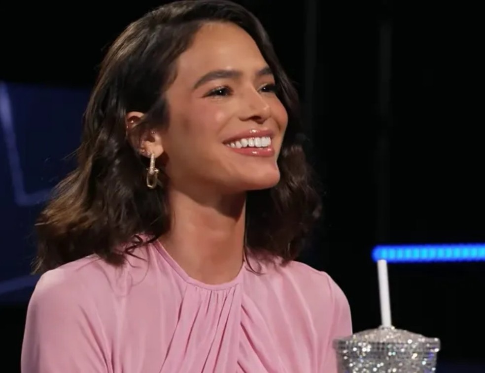 Bruna Marquezine não segurou o riso ao ser questionada sobre um 'livramento' em sua vida — Foto: Reprodução YouTube
